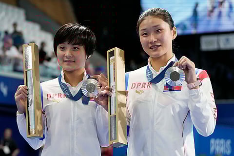 North Korea's Jo Jin Mi and Kim Mi Rae pose with their silver medal